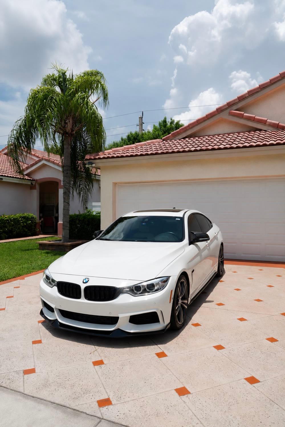 A white BMW coupe, cleaned and gleaming on a driveway in Pembroke Pines